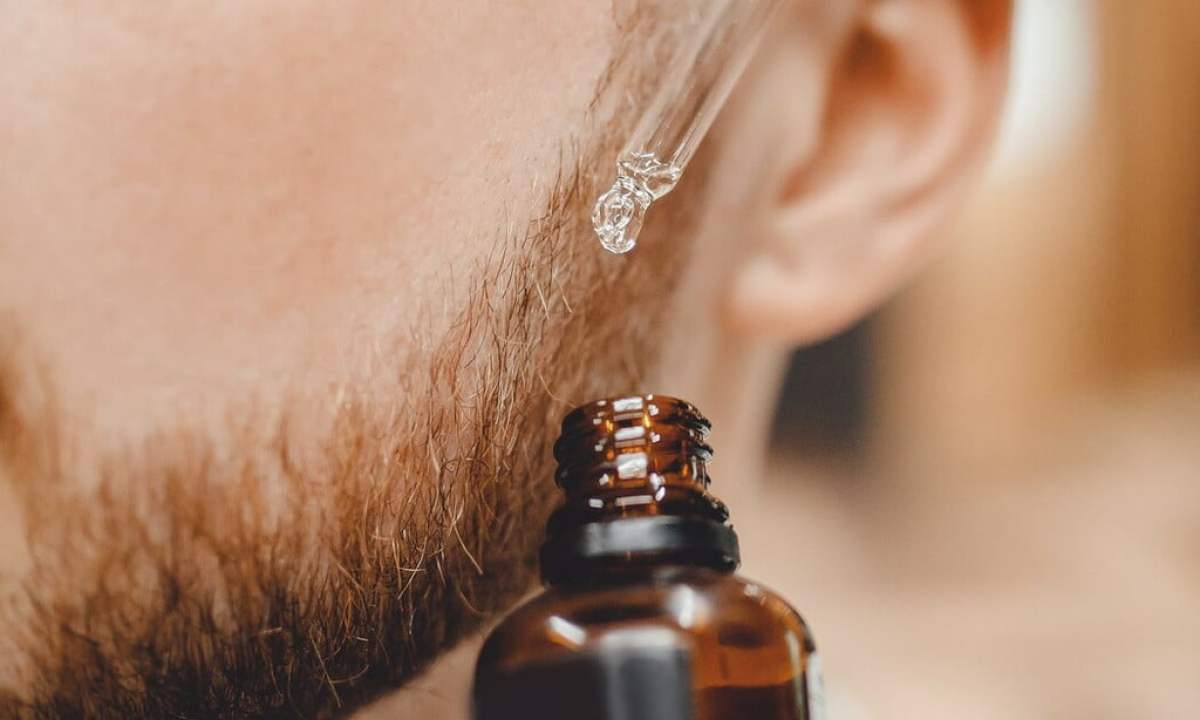 Man putting beard oil on his beard.