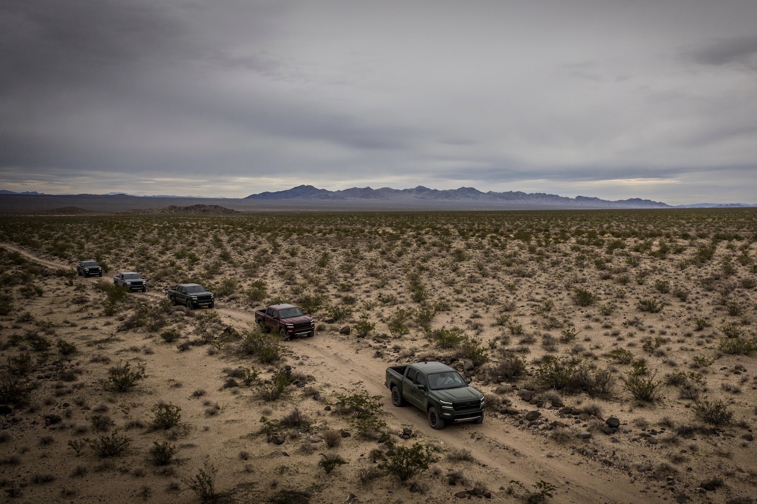 Overhead photo of 2022 Nissan Frontier Pro-4X off-roading through the desert with mountains in the back.